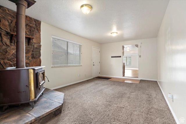 148 N 100 E, American Fork, UT 84003 - unfurnished living room with a wood stove, carpet, a textured ceiling, and baseboards