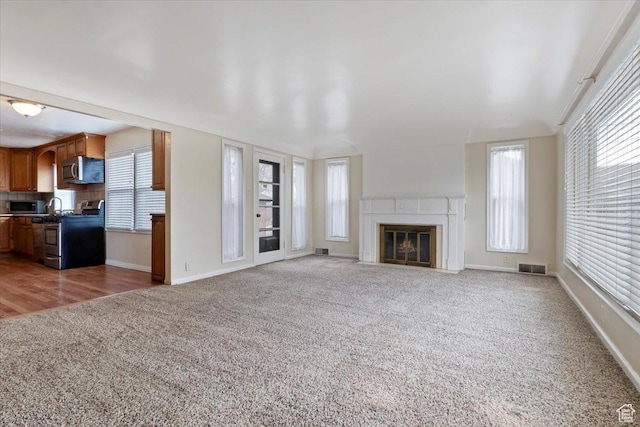 148 N 100 E, American Fork, UT 84003 - unfurnished living room with carpet flooring, visible vents, and a wealth of natural light