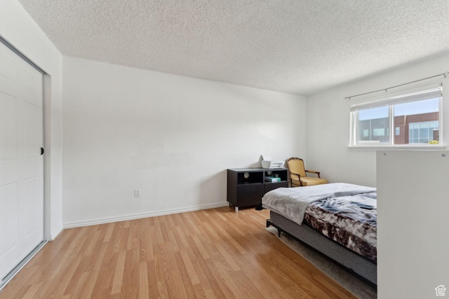 1601 W 400 S Unit 26, Salt Lake City, UT 84104 - bedroom featuring a textured ceiling, light wood finished floors, and baseboards