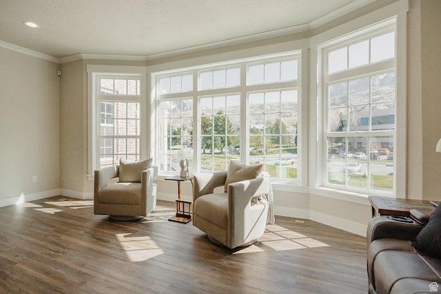 interior space with baseboards, crown molding, and wood finished floors