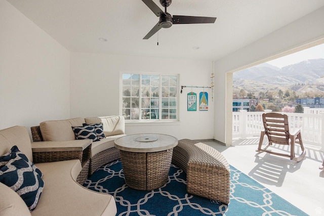 carpeted living room with a mountain view, a ceiling fan, and plenty of natural light