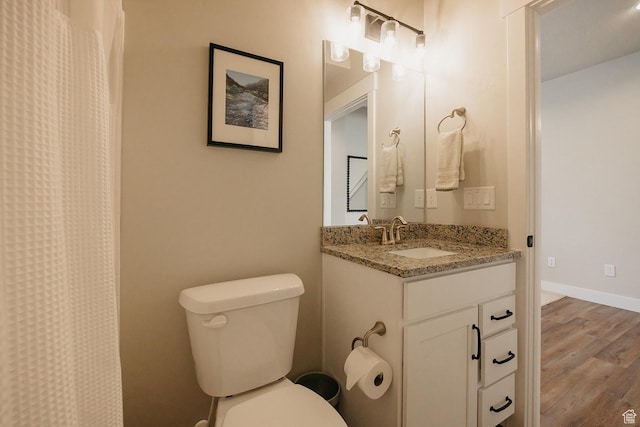 full bath featuring vanity, baseboards, toilet, and wood finished floors