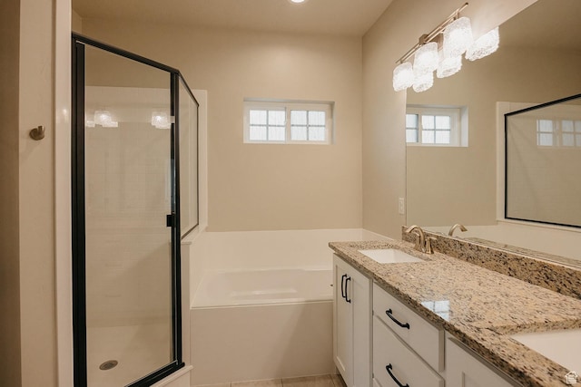 bathroom with a bath, a stall shower, double vanity, and a sink