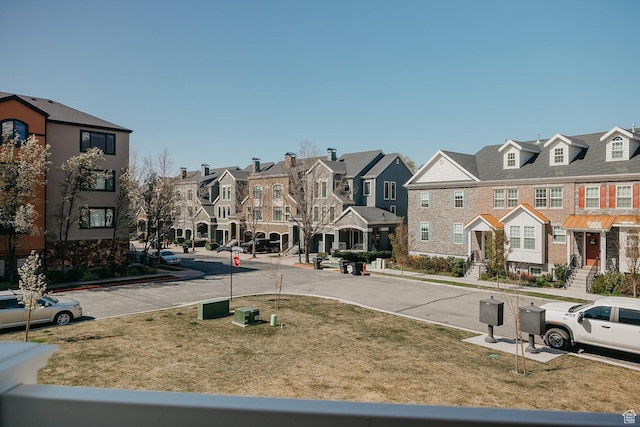 view of street with sidewalks, a residential view, curbs, and traffic signs