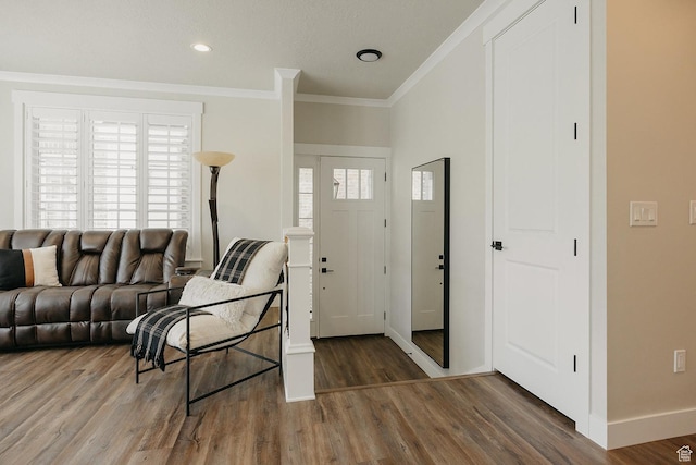 foyer with crown molding, baseboards, plenty of natural light, and wood finished floors