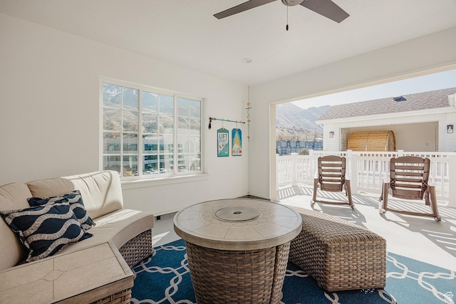 living area with a mountain view and a ceiling fan