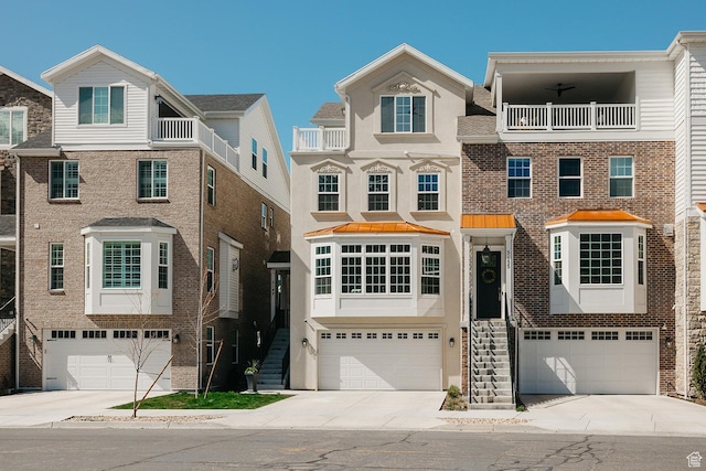 multi unit property with an attached garage, concrete driveway, and stucco siding
