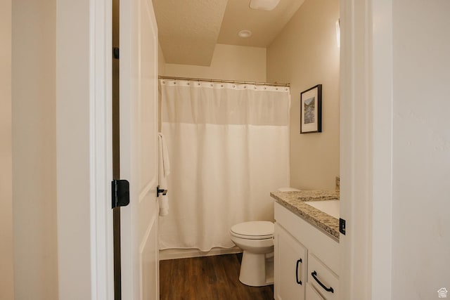full bathroom with vanity, curtained shower, a textured ceiling, toilet, and wood finished floors
