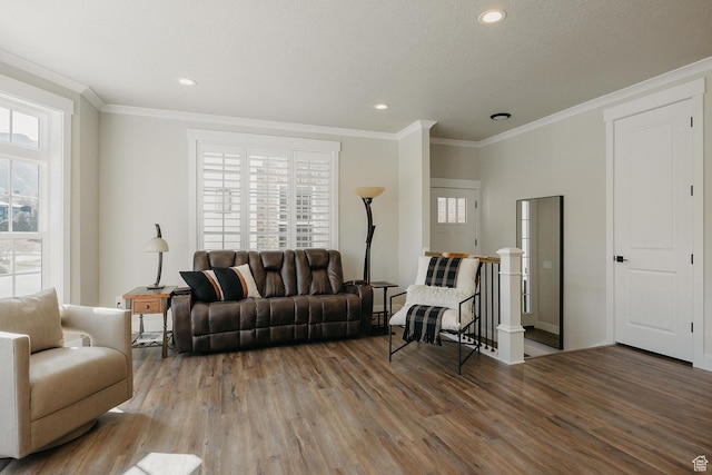 living room featuring recessed lighting, a textured ceiling, crown molding, and wood finished floors