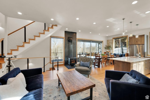 10802 E Green Briar Rd Unit 562, Heber City, UT 84032 - living room featuring light wood-style floors, a wood stove, stairway, and recessed lighting