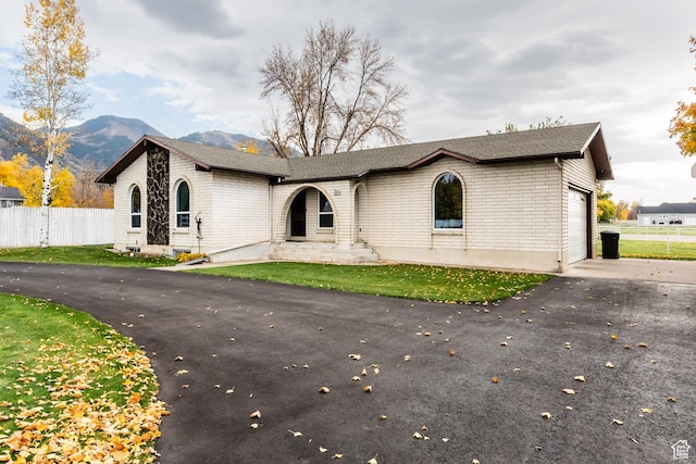 314 W 100 S, Providence, UT 84332 - ranch-style home with fence, aphalt driveway, a mountain view, and an attached garage