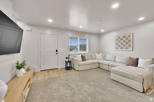 living area featuring visible vents, light wood-type flooring, recessed lighting, and baseboards