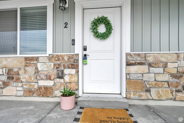 entrance to property with board and batten siding and stone siding