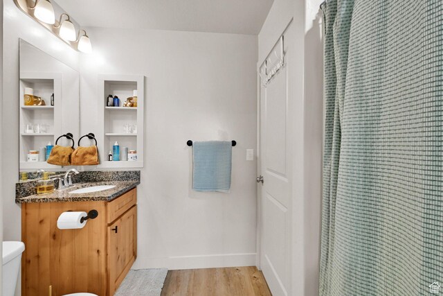 bathroom with vanity, baseboards, curtained shower, toilet, and wood finished floors