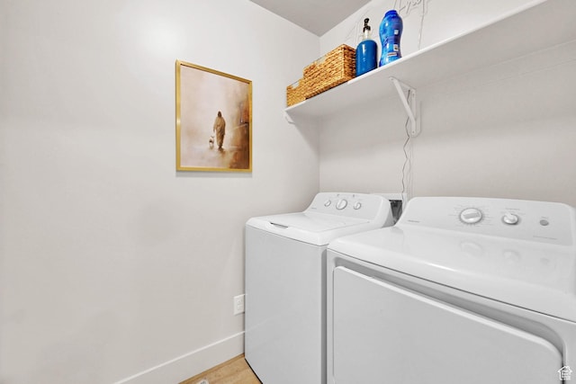 laundry area with light wood-style flooring, independent washer and dryer, laundry area, and baseboards