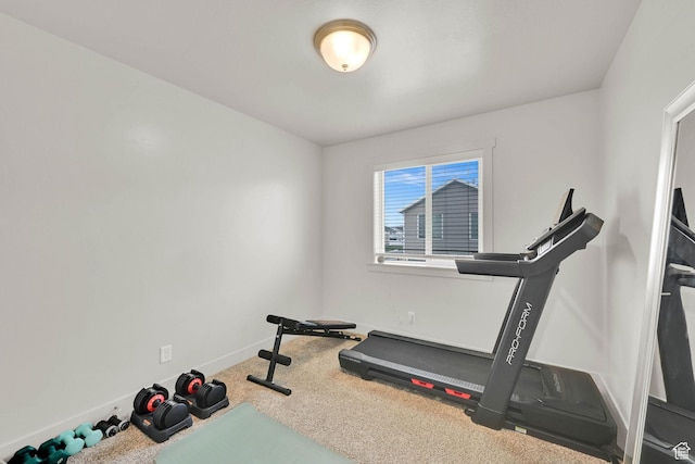 workout area featuring baseboards and carpet