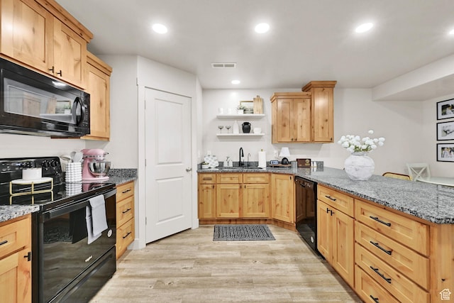 kitchen featuring light wood-type flooring, a peninsula, open shelves, visible vents, and black appliances