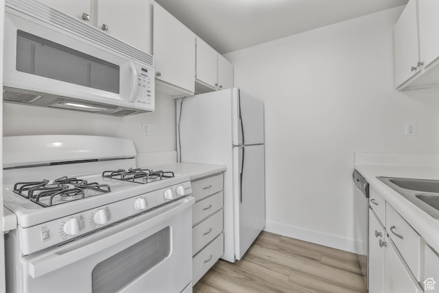 kitchen featuring white appliances, light wood-style floors, white cabinetry, and light countertops