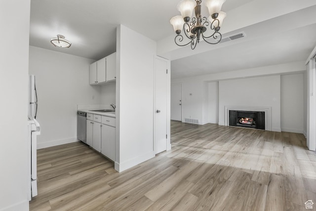 kitchen featuring light wood-style flooring, visible vents, a sink, light countertops, and stainless steel dishwasher