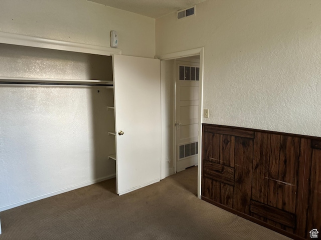 unfurnished bedroom with visible vents, carpet flooring, and a closet