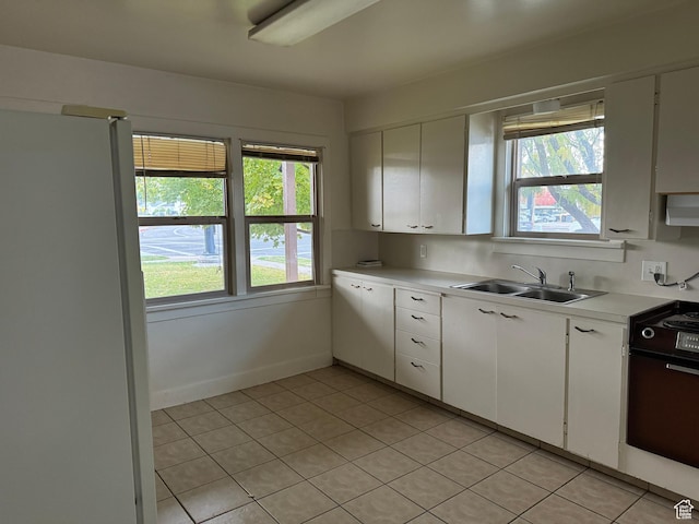 kitchen featuring a sink, light countertops, range, and a healthy amount of sunlight