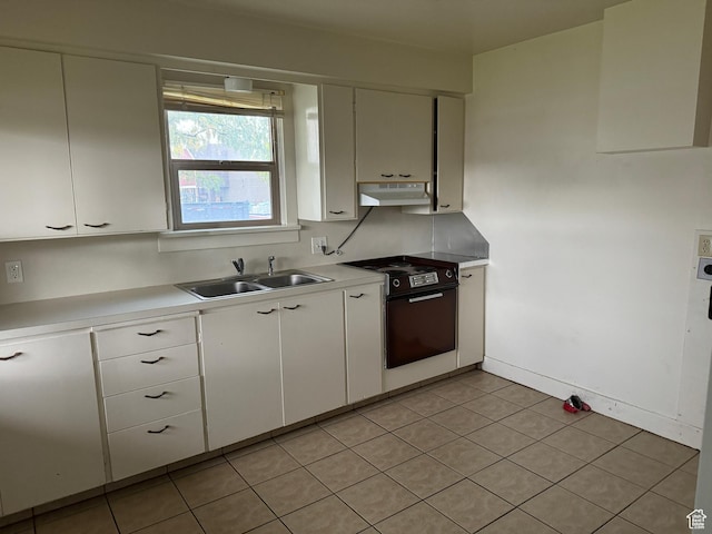 kitchen featuring white cabinets, range with electric stovetop, a sink, light countertops, and under cabinet range hood