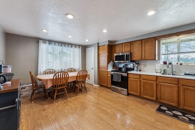 2013 W Mark St, Layton, UT 84041 - kitchen featuring brown cabinetry, light wood-style flooring, recessed lighting, appliances with stainless steel finishes, and light countertops