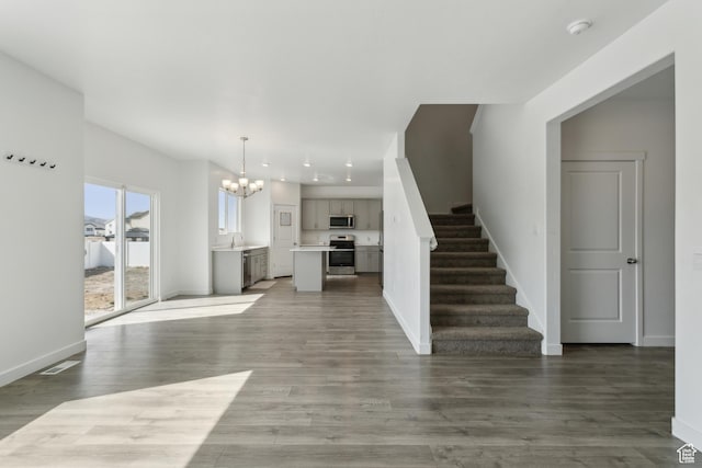 13 N N Maraschino Ln, Grantsville, UT 84029 - unfurnished living room with stairs, visible vents, baseboards, and an inviting chandelier