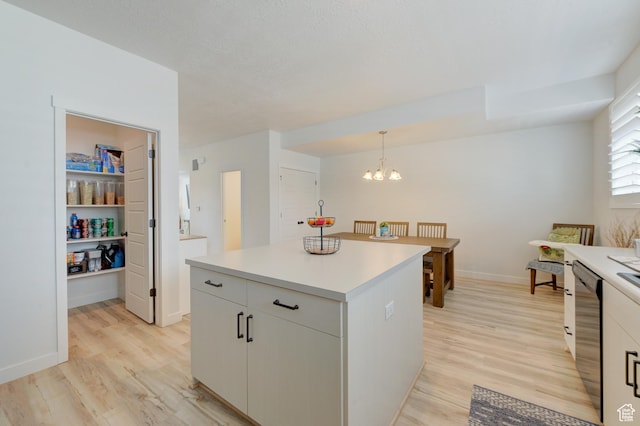 4696 W Talavera Way, Kearns, UT 84118 - kitchen with a chandelier, light countertops, a kitchen island, light wood finished floors, and pendant lighting