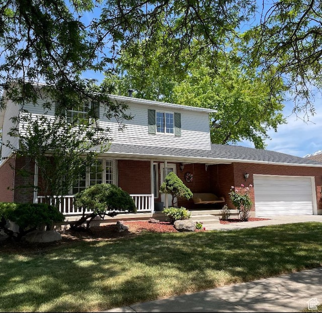 5085 Clover View Dr Unit 11, Murray, UT 84123 - traditional-style home featuring covered porch, brick siding, a front lawn, and a garage
