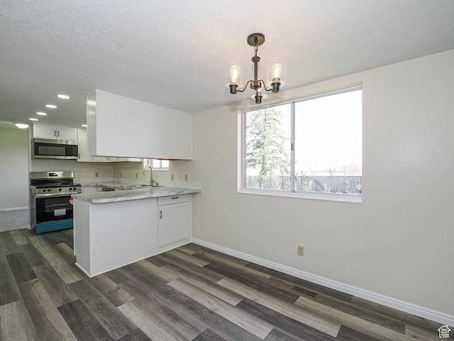 5085 Clover View Dr Unit 11, Murray, UT 84123 - kitchen featuring visible vents, baseboards, an inviting chandelier, a peninsula, and stainless steel appliances