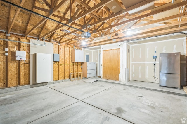 281 W Calias Ln, Stansbury Park, UT 84074 - garage featuring a garage door opener and freestanding refrigerator