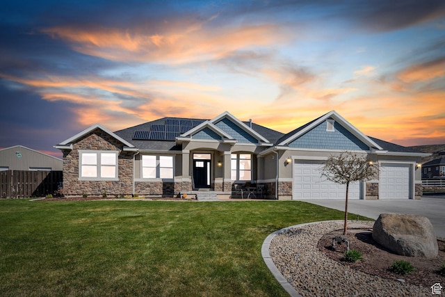 2155 E Blue Sky Dr, Eagle Mountain, UT 84005 - craftsman-style house with roof mounted solar panels, an attached garage, stone siding, a lawn, and fence