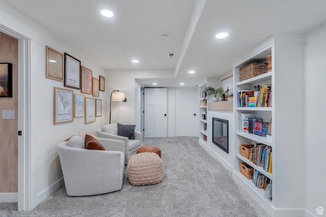 2155 E Blue Sky Dr, Eagle Mountain, UT 84005 - carpeted living area with built in features, a glass covered fireplace, visible vents, recessed lighting, and baseboards