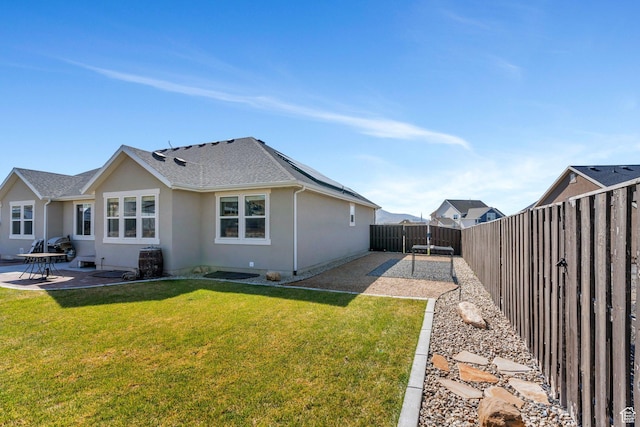 2155 E Blue Sky Dr, Eagle Mountain, UT 84005 - rear view of property featuring a fenced backyard, stucco siding, a lawn, a patio, and solar panels