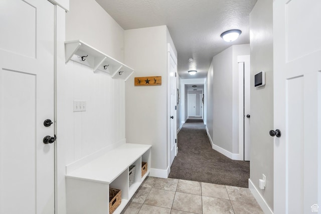 2155 E Blue Sky Dr, Eagle Mountain, UT 84005 - mudroom featuring light carpet, light tile patterned floors, baseboards, and a textured ceiling