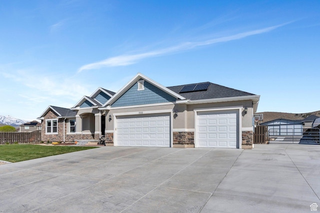 2155 E Blue Sky Dr, Eagle Mountain, UT 84005 - view of front of home featuring stucco siding, fence, stone siding, solar panels, and driveway