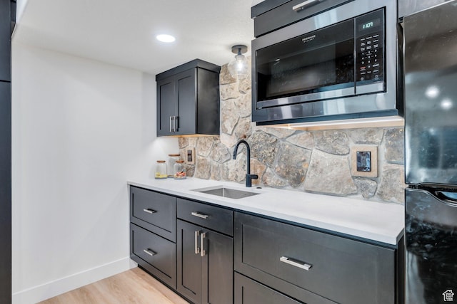 2155 E Blue Sky Dr, Eagle Mountain, UT 84005 - kitchen with tasteful backsplash, light countertops, freestanding refrigerator, built in microwave, and a sink