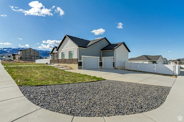 542 W Coyote Ridge Rd Unit 20, Grantsville, UT 84029 - view of front of property featuring board and batten siding, fence, a front lawn, a gate, and concrete driveway