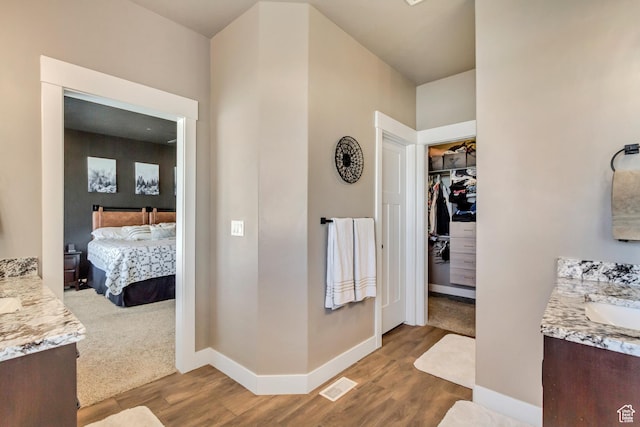 542 W Coyote Ridge Rd Unit 20, Grantsville, UT 84029 - full bathroom with visible vents, baseboards, ensuite bath, wood finished floors, and two vanities