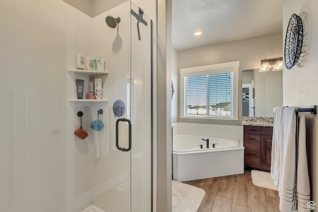 542 W Coyote Ridge Rd Unit 20, Grantsville, UT 84029 - full bathroom with a shower stall, vanity, a garden tub, and wood finished floors