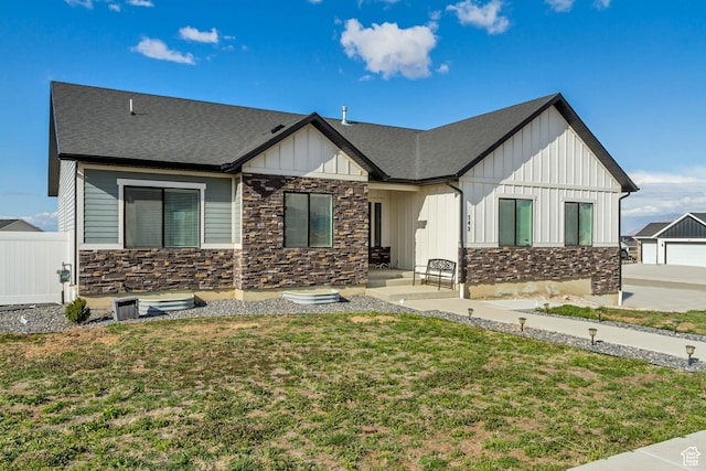 542 W Coyote Ridge Rd Unit 20, Grantsville, UT 84029 - view of front of house featuring a front yard, roof with shingles, board and batten siding, and stone siding