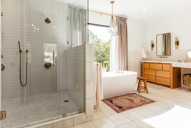 4155 S Parkview Dr, Salt Lake City, UT 84124 - bathroom featuring vanity, a soaking tub, tile patterned flooring, a shower stall, and tile walls