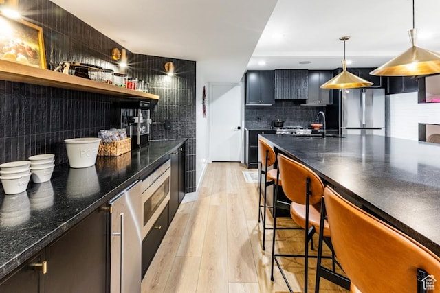 4155 S Parkview Dr, Salt Lake City, UT 84124 - kitchen featuring open shelves, a sink, freestanding refrigerator, a kitchen breakfast bar, and decorative backsplash