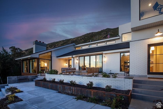 4155 S Parkview Dr, Salt Lake City, UT 84124 - rear view of house featuring brick siding, a mountain view, an outdoor living space, and a patio