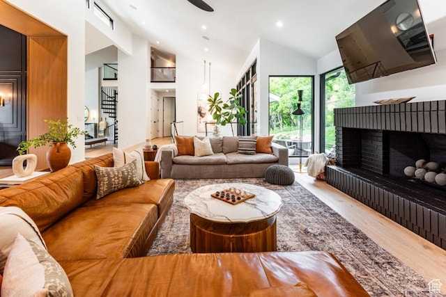 4155 S Parkview Dr, Salt Lake City, UT 84124 - living room with recessed lighting, stairs, a fireplace with raised hearth, high vaulted ceiling, and wood finished floors
