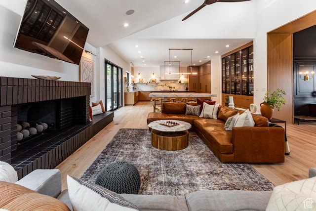 4155 S Parkview Dr, Salt Lake City, UT 84124 - living area featuring a fireplace with raised hearth, light wood-type flooring, a ceiling fan, and lofted ceiling