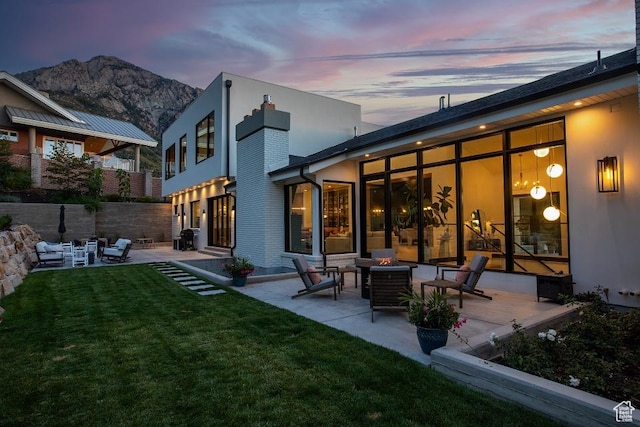 4155 S Parkview Dr, Salt Lake City, UT 84124 - back of property at dusk featuring a mountain view, a patio area, an outdoor fire pit, a yard, and a chimney