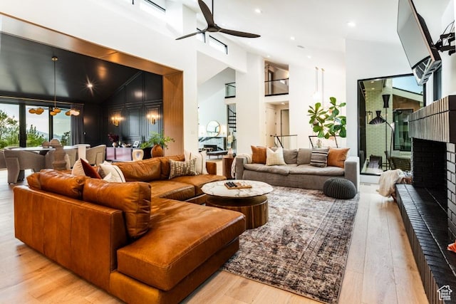 4155 S Parkview Dr, Salt Lake City, UT 84124 - living area featuring ceiling fan with notable chandelier, wood finished floors, a brick fireplace, and high vaulted ceiling