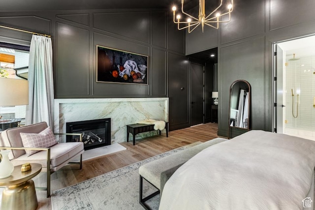 4155 S Parkview Dr, Salt Lake City, UT 84124 - bedroom featuring a decorative wall, a notable chandelier, wood finished floors, and a high end fireplace